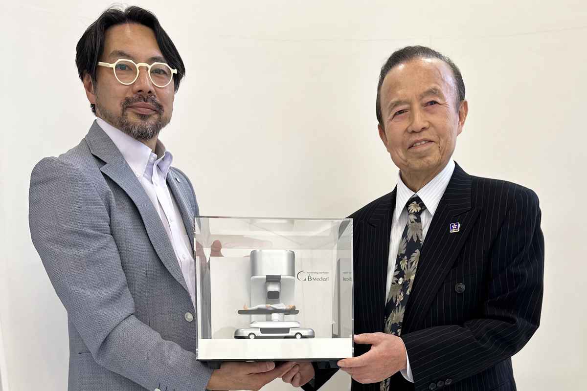 加藤正二郎院长（左）和吉田嘉明手持 B.Dot Medical 质子束治疗装置模型（江户川医院集团提供）